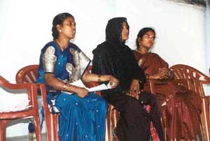 Committee members speak at a monthly meeting for Women's Self Help Groups.
